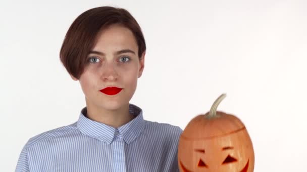 Jonge vrouw op zoek geschokt, poserend met halloween pompoen gesneden — Stockvideo