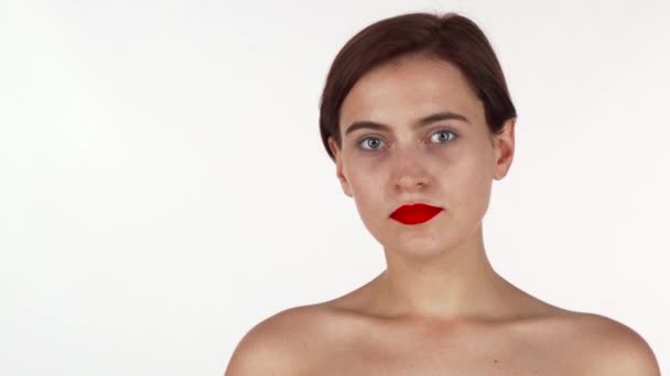 Потрясающая брюнетка с красными губами задумчиво смотрит в камеру — стоковое видео