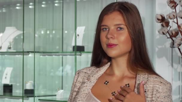 Mooie jonge vrouw in de spiegel, kijken proberen op een ketting bij juwelier — Stockvideo