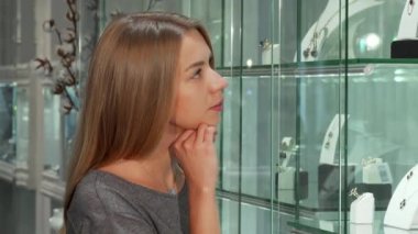Çekici genç kadın müşteri ekran mücevher mağazasında incelenmesi