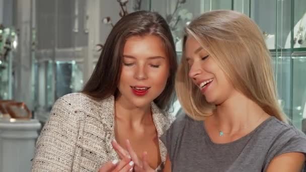 Vriendinnen proberen op ringen bij de juwelier tijdens het winkelen samen — Stockvideo