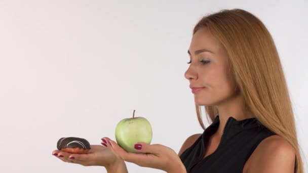 Jovem mulher olhando confuso escolher entre saudável e junk food — Vídeo de Stock
