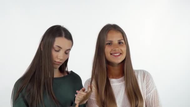 Молодая женщина гладит длинные здоровые волосы своей лучшей подруги — стоковое видео
