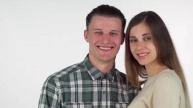 Mutlu genç çift neşeyle gülümseyen kendi elleriyle kalp oluşturan