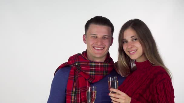 Pareja feliz en ropa de invierno celebrando algo, tintineo copas de champán — Vídeos de Stock