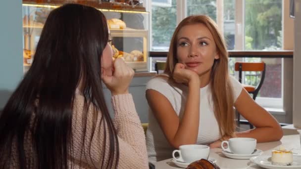 Mujer atractiva hablando con su mejor amiga en la cafetería — Vídeos de Stock