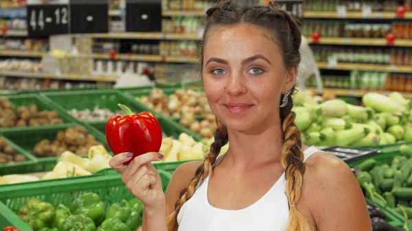Gyönyörű fiatal nő szagú paprika a szupermarketben — Stock Fotó