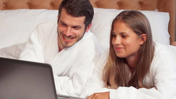 Щаслива пара посміхається до камери в їх люкс на медовий місяць — стокове фото
