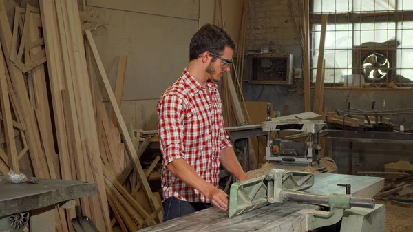 Joven carpintero macho moliendo madera en su taller —  Fotos de Stock