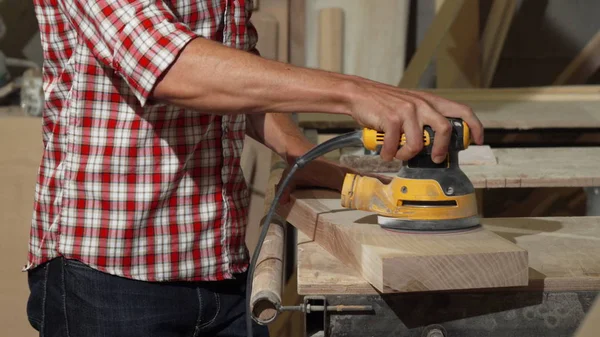 Carpintero macho pulido pieza de madera en su taller — Foto de Stock