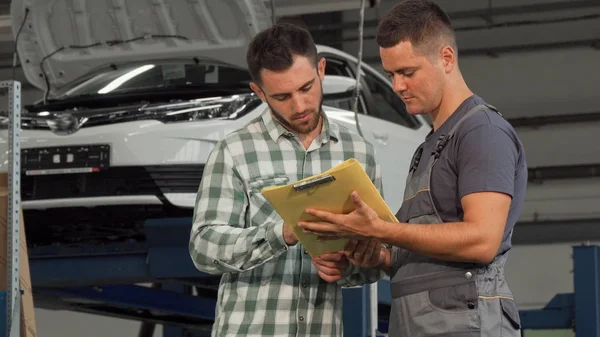 Mutlu adam arabasını tamir benzinlikte aldıktan sonra belgeleri imzalama