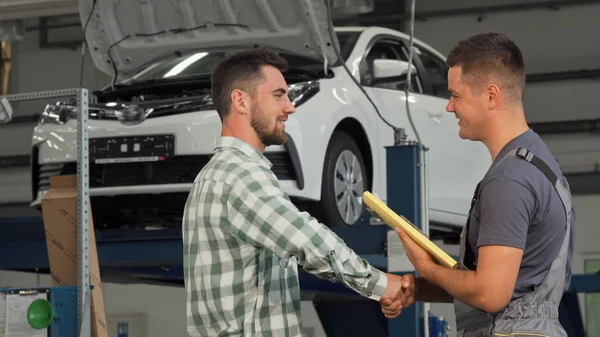 Dikiz atış bir mekanik ve garajda tokalaşırken müşteri