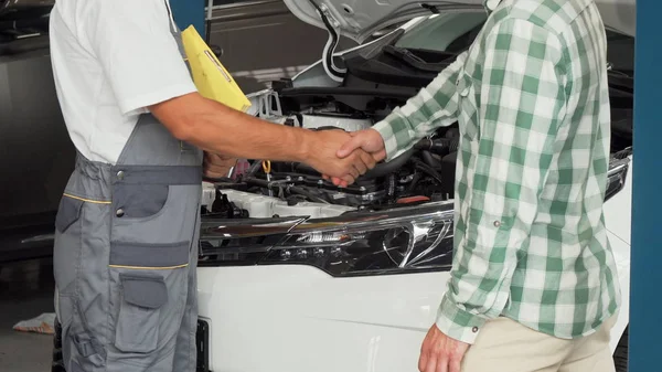 サービス ステーションでの自動車整備士と握手の車の所有者 — ストック写真