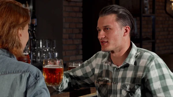 Genç çift, birlikte bira yudumlarken sohbet