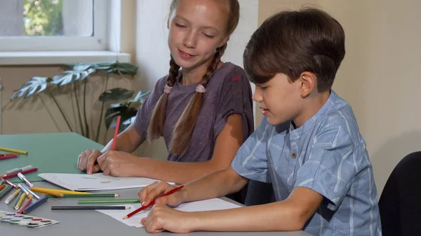 Twee kinderen genieten van praten en tekenen bij kunst-klasse samen — Stockfoto