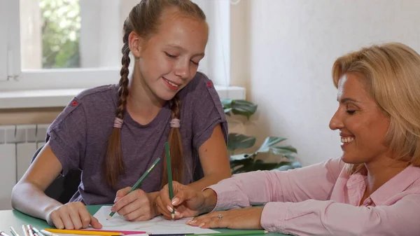 Feliz profesora madura dibujando con su estudiante en la escuela — Foto de Stock