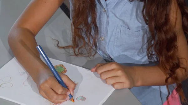 Linda niña pelirroja sonriendo alegremente, mientras dibuja — Foto de Stock