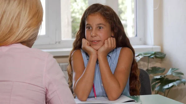 Schattig gelukkig jong meisje praten met haar leraar op klasse — Stockfoto