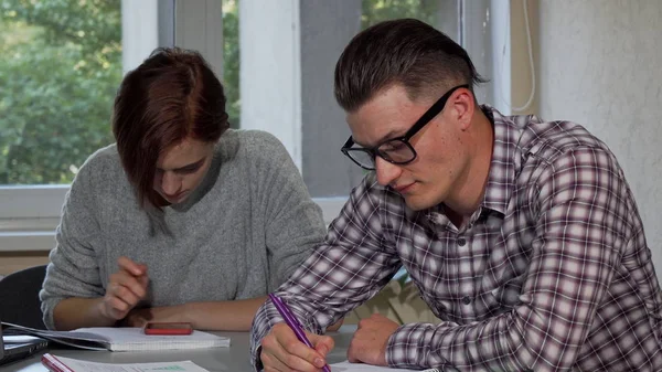 Male student taking off his glasses, looking tired while studying — Stock Photo, Image