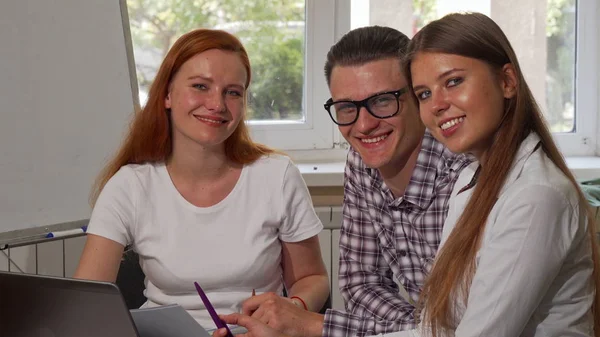 Groep van jonge ondernemers glimlachen naar de camera tijdens het werken samen — Stockfoto