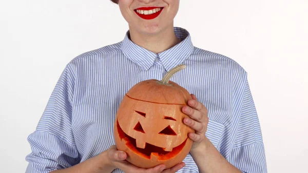 Woman wearing red lipstick holding up carved halloween pumpkin — Stock Photo, Image