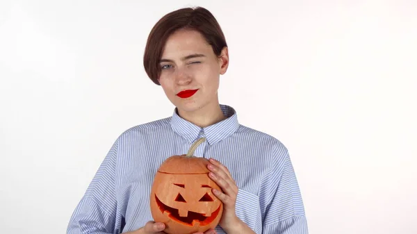 Vacker kvinna med röda läppar ler glatt, holding Halloween pumpa — Stockfoto