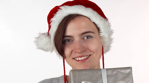 Atractiva mujer de Navidad escondiendo su cara detrás de una caja de regalo —  Fotos de Stock
