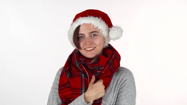 Ευτυχισμένη γυναίκα φοράει καπέλο Χριστουγέννων και χειμερινά κασκόλ χαμογελά στη φωτογραφική μηχανή — Φωτογραφία Αρχείου