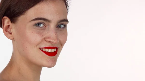 Привлекательная женщина с красными губами, улыбающаяся в камеру изолированной — стоковое фото