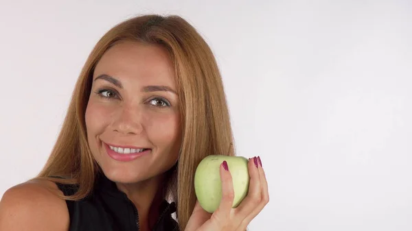 Щаслива здорова красива жінка весело посміхається, тримаючи яблуко — стокове фото