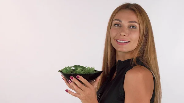 Щаслива здорова жінка насолоджується запахом свіжого смачного салату — стокове фото