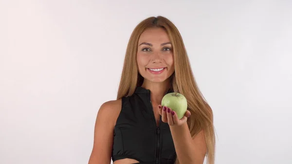 Красива здорова жінка посміхається, тримаючи смачне яблуко в камеру — стокове фото