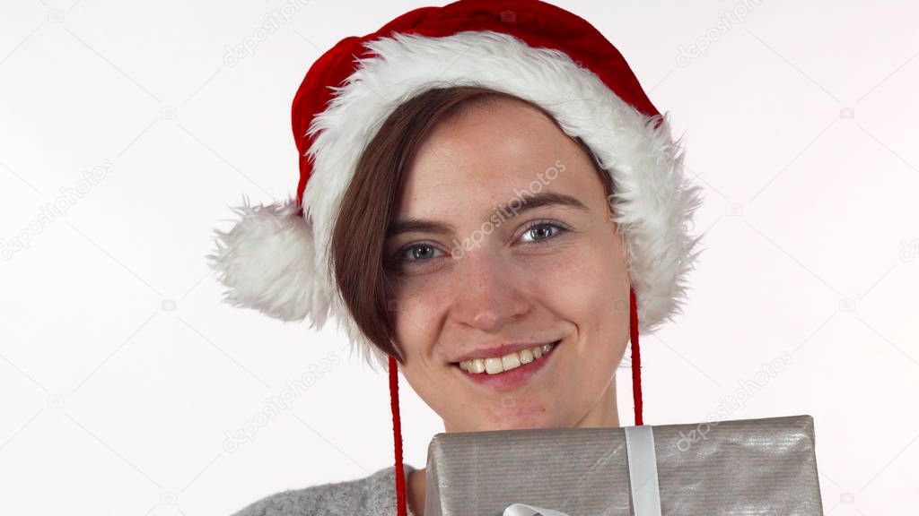 Attractive Christmas woman hiding her face behind a present box
