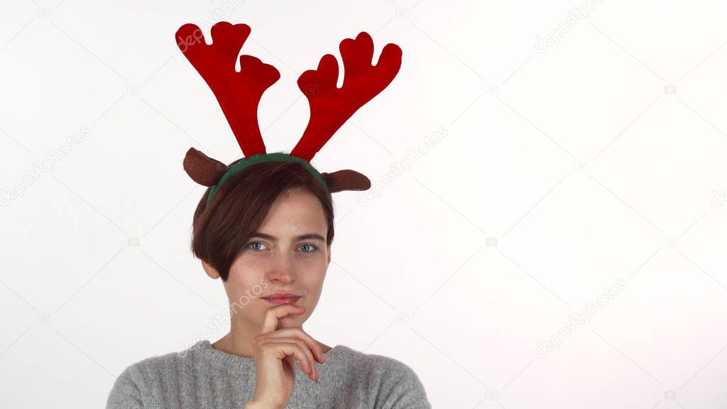 Attractive Christmas girl looking thoughtfully to the camera, isolated
