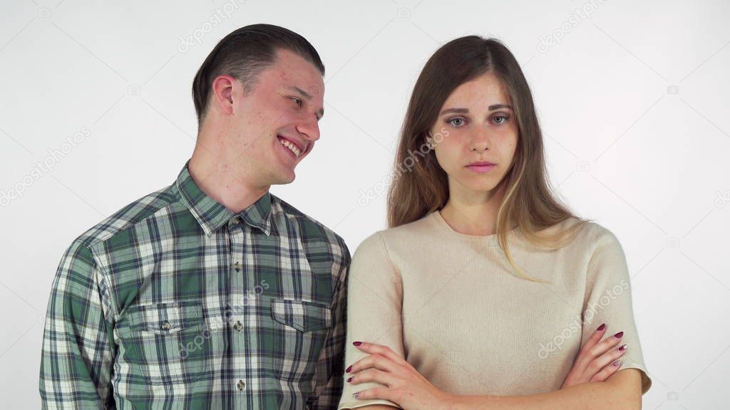 Cheerful handsome man laughing at his annoyed girlfriend, isolated