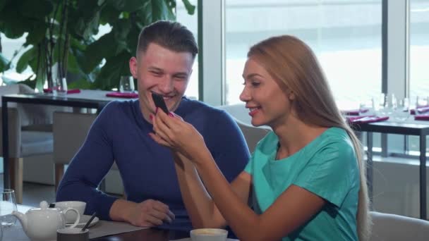 Güzel kadın ve erkek arkadaşı akıllı telefonda bir şey okuma — Stok video