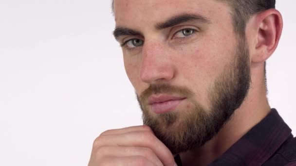 Un bell'uomo serio che distoglie lo sguardo pensieroso, strofinandosi la barba — Video Stock