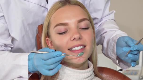 Mutlu dişlerini aldıktan sonra kameraya gülümseyen kadın diş hekimi tarafından kontrol — Stok video