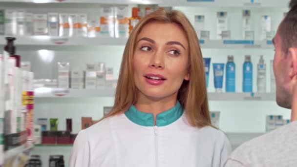 Farmacêutica feminina amigável ajudando um cliente na farmácia — Vídeo de Stock