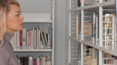 Muhteşem kadın kitapçı dükkanında alışveriş rafları düşünceli arıyorum