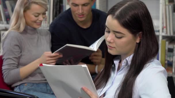 Krásná studentka psaní ve své učebnici koukal zamyšleně — Stock video