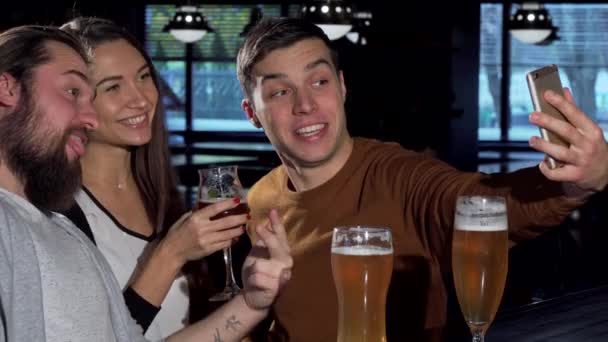 Grupa przyjaciół, biorąc selfie z inteligentnych telefonów, pijąc piwo razem — Wideo stockowe