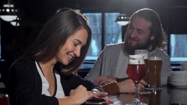Arkadaş grubu bira içiyor onun akıllı telefon kullanan güzel mutlu kadın — Stok video