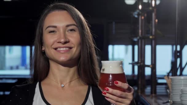 Linda mulher feliz sorrindo, segurando sua cerveja para a câmera — Vídeo de Stock