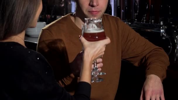 可爱的夫妇叮当作响他们的啤酒杯, 庆祝周年在餐厅 — 图库视频影像