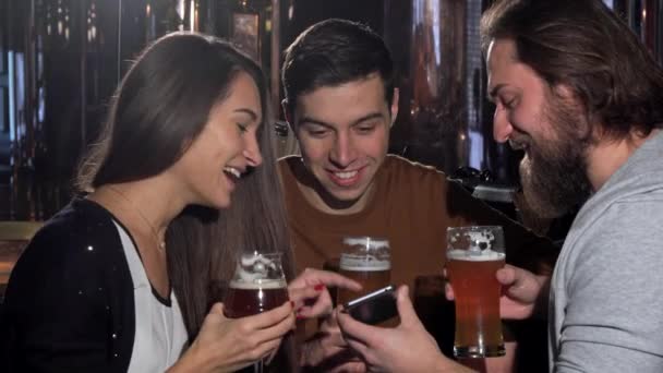 Groupe d'amis s'amuser au pub de bière, en utilisant le téléphone intelligent ensemble — Video