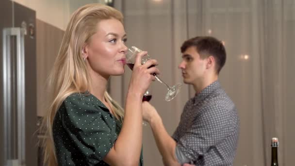 Feliz pareja amorosa sonriéndose, bebiendo vino en casa — Vídeo de stock