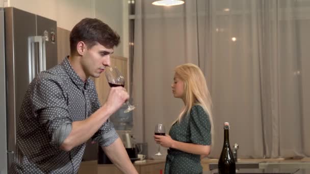 Handsome man drinking wine after having a fight with his girlfriend at home — Stock Video