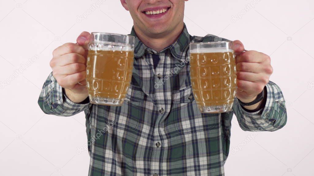 Happy man smiling, holding out two beer mugs to the camera