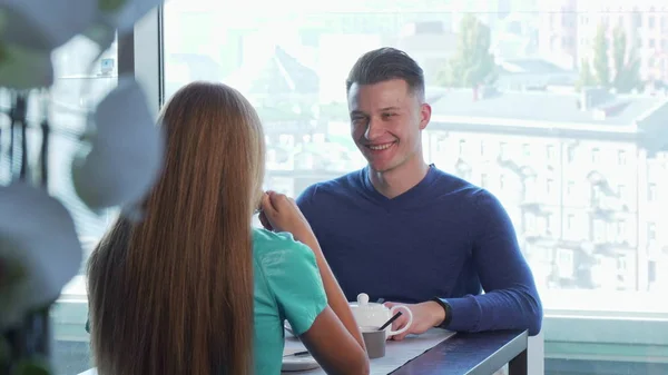 Красивий веселий чоловік зустрічається зі своєю дівчиною, насолоджуючись сніданком разом — стокове фото